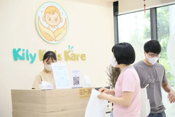 Lễ tân tiếp đón phụ huynh đưa bé đi khám